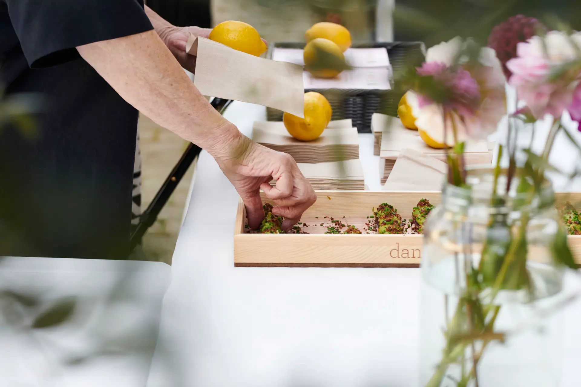 Billede af en person, der forbereder smørrebrød til et event med Danish Minies